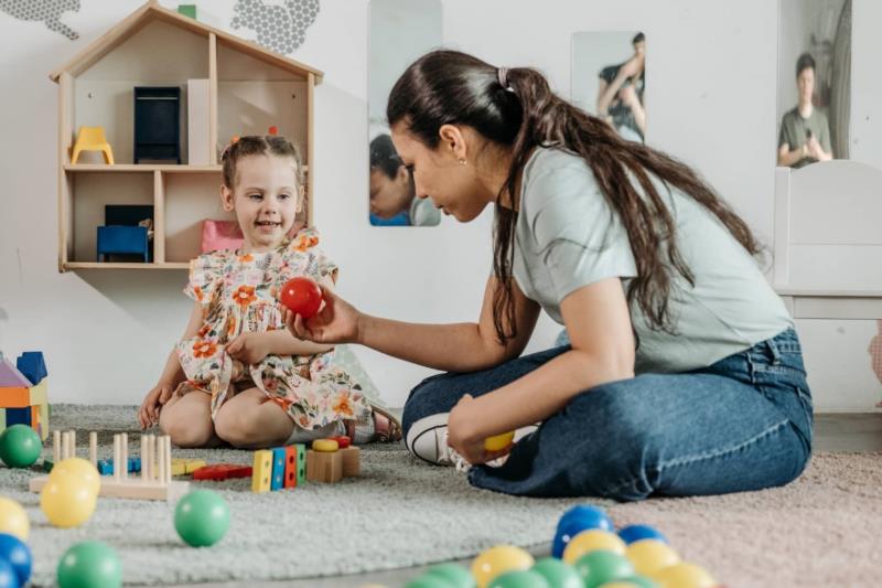 Family child care provider works with a young child in a home-based child care program
